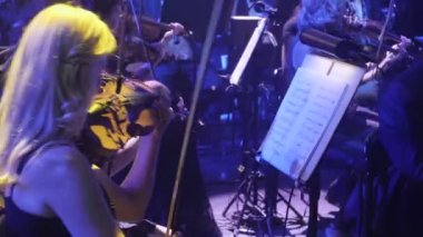 Rock Senfoni konser Kiev Ukrayna orkestra şefi Nikolai Lysenko kemancılar tutkuyla standları karanlık Hall ışıklar bir yay müzik kitapları ile oynuyor