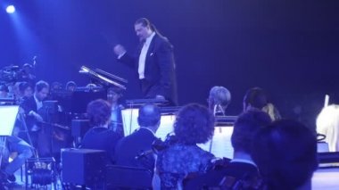 İletken müzisyenler vardır çello çalmaya ve keman müzik kitap mavi aydınlatma standları Rock Senfoni konser Ukrayna tur Kiev Nikolai Lysenko olduğunu