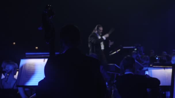 Rock symfoni konsert ukrainska tur Kiev Nikolai Lysenko är genomföra musiker är spela cello med ett bågar musikböcker om står blå belysning — Stockvideo