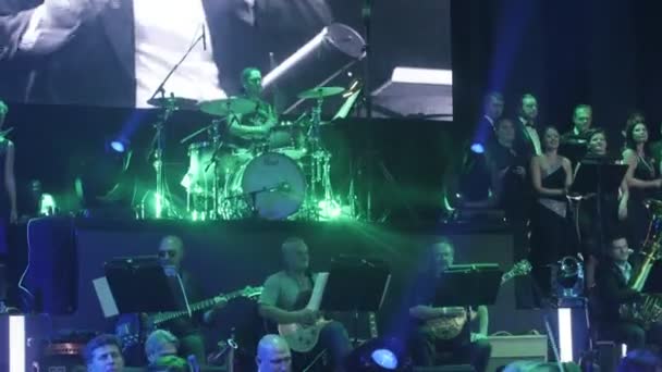 Rock Szimfonikus koncert ukrán Tour Kiev karmester Nyikolaj Lysenko zenészek is játszik kórus az éneklés operatőr nagy képernyők megvilágítás sötét Hall — Stock videók