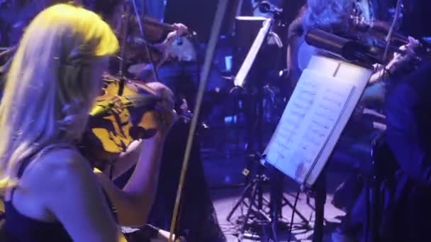 Rock Senfoni konser Kiev Ukrayna orkestra şefi Nikolai Lysenko kemancılar tutkuyla standları karanlık Hall ışıklar bir yay müzik kitapları ile oynuyor — Stok video