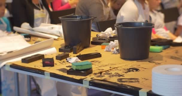 Дети-родители рисуют в художественной галерее Люди, сидящие за столом краски в детском саду Семейный мастер-класс Педагоги Аниматоры развлекают детей — стоковое видео