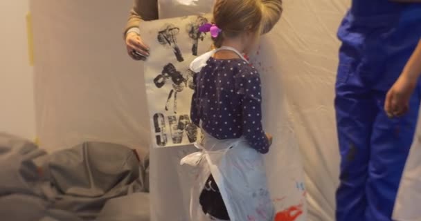 Παιδί και γυναικών σε ποδιές εκπαιδευτικοί δείχνουν παιδικό σχέδιο άνθρωπος είναι χειροκροτούν άτομα είναι ζωγραφική τέχνη Νηπιαγωγείο εκπαιδευτικοί στην τάξη τα παιδιά και τους γονείς — Αρχείο Βίντεο