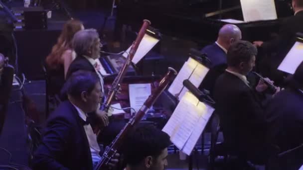 Συμφωνική συναυλία Κίεβο μαέστρος Nikolai Lysenko ομάδα βράχο της Bassoonists μουσικοί παίζουν Fagottos μουσικά βιβλία σε περίπτερα λαμπτήρες φωτισμού σκοτεινή αίθουσα — Αρχείο Βίντεο