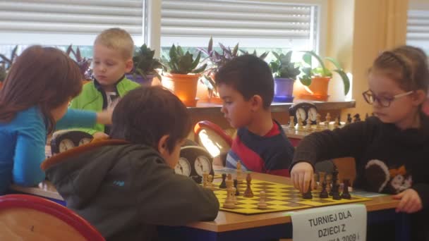 チェス トーナメント子供が再生チェス子供座ってアクロスから互いにタイマー チェス クラブ"黒騎士に回転移動を作るトレーニングします。" — ストック動画