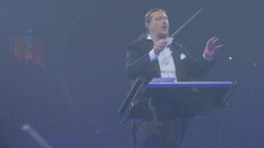 Sallamak Senfoni konser Kiev iletken adam Baton müzisyenler sallayarak iletken ile absorbe Mavi ışıklar Senfoni Orkestrası tekrarı oynuyor
