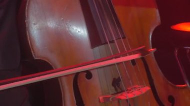 Smokin güzel ahşap dize enstrüman Rock Senfoni konser Kiev Senfoni Orkestrası yay iyi giyimli müzisyen ile Çello çalan adamın elleri