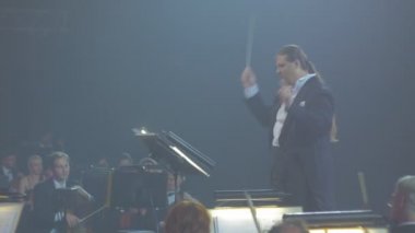 Rock Senfoni konser Kiev heyecanlı iletken bir Baton yeşil ışık müzisyenler sallayarak vardır oynarken müzik kitap standları Senfoni Orkestrası performansına
