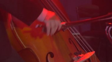 Çello yayı iyi giyimli çellist genç adam smokin güzel ahşap dize enstrüman Rock Senfoni konser Kiev performansı oynayan adamın elleri müzisyen