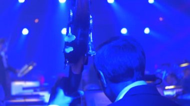 Orkestra şefi müzik kitap standları seyirci bir Hall Rock Senfoni konser Kiev müzisyenler vardır oynarken Mavi ışıklar üzerinde oynarken çello bakıyor çellist adamdır