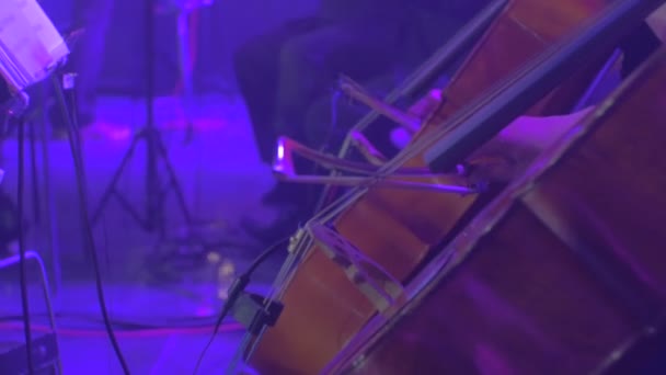 Müzisyenler kadın eli çello müzik kitap standları oynar müzisyenler yay ile oynuyor Rock Senfoni konser Kiev müzisyenleri Mavi ışıklar oynuyor — Stok video