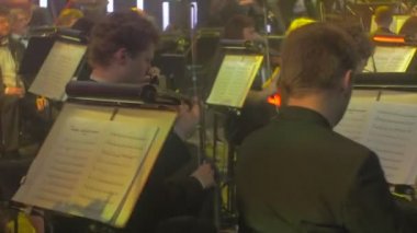 Rock Senfoni Konserkiev Uzun Saçlı Adam Şef bir Smokin sallayarak bir Baton Kemancılar Bir Konser Salonu'nda Standları İzleyiciler Müzik Kitapları Oynuyor