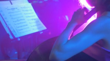 Kadın müzik kitap standları bakarak çello oynuyor müzisyenler yay ile oynuyor Rock Senfoni konser Kiev müzisyenleri Mavi ışıklar oynuyor