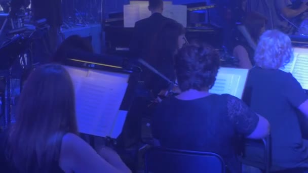 Rock Symphony concert Kiev violisten spelen snelle melodie einde het spel licht gaat uit muzikanten van het orkestmuziek boeken verlichting Dark Hall — Stockvideo