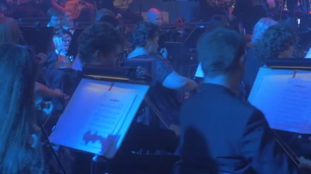 Rock Symphony Concert Kiev kvinnliga violinister grupp av musiker långhårig man människor spelar musik böcker på står rytmiska ljuseffekter blått ljus — Stockvideo