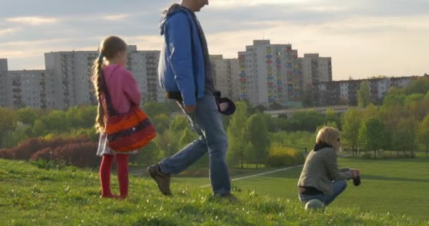 Constitution Jour Opole Famille sur une colline avec chien reposant sur l'herbe dans le parc Chien court après la balle que l'homme donne des coups de pied Printemps Homme Femme Passez du temps ensemble — Video