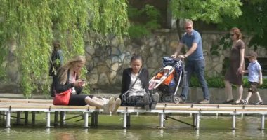 Opole şehir gün iki genç kadın güneşli gün kızlar güverteye su üzerinde oturup Park'ta rahatlatıcı bir tanesi uğrayacağız onun telefon manifatura insanlar Tıklanma