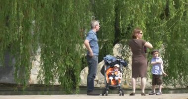 Opole kadın kamera ile günde şehir resimleri görünüyor etrafında baba anne ayırdığınız için yer seçer ve hafta sonları birlikte Park Lake yakınındaki iki çocuk harcamak