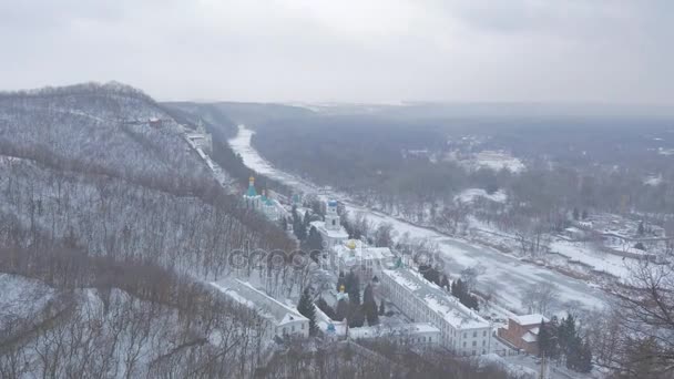 中年男子看着 Sviatogorskaya 修道院从观景台的阿尔纪念碑在下雪的冬天 — 图库视频影像