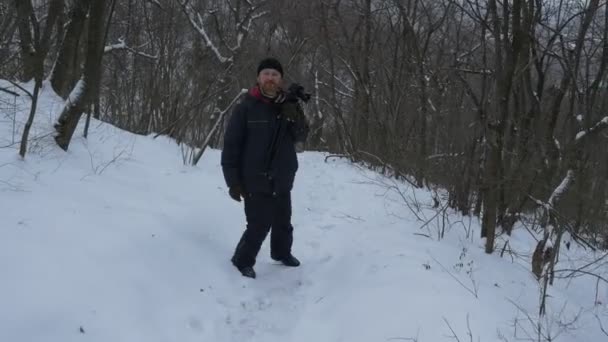 Egy vallási középső idős ember megy le a hegyről, a Sviatogorky Manastery nemzeti parkban található, festői hegyek hóval télen — Stock videók