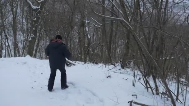彼の手は、雪に覆われた冬の Sviatogorky 洞窟修道院の国立公園の斜面に沿って歩いてステディカムと髭の男 — ストック動画