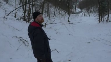 Orta yaşlı adam elinde bir Stedicam kamera ile bir karlı dağ yamaç ve Sviatogorky Parkzone pitoresk perçinleme sayısı bakar iner