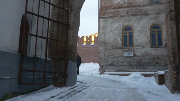 Un grande arco di Uspensky Santa Cattedrale Cristiana con cancelli in metallo e mezza rotonda finestre in legno e un uomo in piedi nel cortile — Video Stock