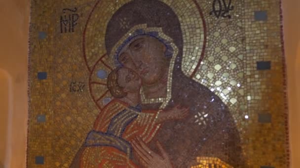 Vieille icône Sainte-Marie en mosaïque dorée avec des bougies traditionnelles lumineuses dans la grotte de craie à Sviatogorskaya Lavra orthodoxe — Video