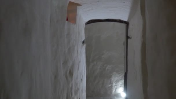 A Semidark Long Narrow Corridor in Chalk Caves, Impressive Arches With Lit Candles, Old Forged Metal Doors, Being Shot With a Steadicam Camera — Stock Video