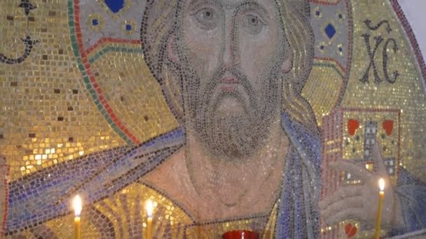 Um ícone mundialmente famoso de Jesus Cristo, mantendo a Bíblia em uma mão, feita de mosaico dourado, e colocada em um arco branco em cavernas de giz — Vídeo de Stock