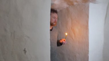 bir sakallı adam gider boyunca bir dar koridora simgesi olan Saint Mary ile Jesus, bebeğim Her el ve Sviatogorskaya Lavra of tebeşir mağaralarda bakar