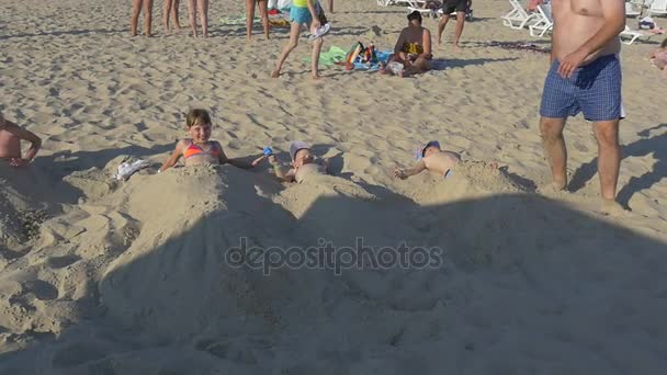 O homem gordo enterra seu filho na areia Videoclipe