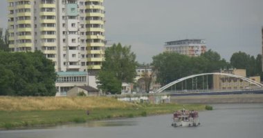 Feribot yüzen bir dere araba Köprüsü güzel çok katlı binalarda yaz gün kemer köprü ulaşım Riverside'ta tarafından nehir kenarında güzel bir şehir boyunca