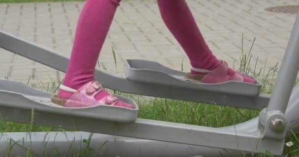 Liten flicka försöker använda en löparbana — Stockvideo