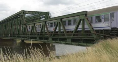 Hızlı Elektrikli tren geçer demiryolu köprüsü üzerinde nehir yaz manzara ulaşım seyahat etmek tren simgesiyle hayatın hızlı kuru ot banka uçar üzgün tarafından