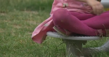 Kız öğrenci bir küçük dönen Platform üzerinde oturur