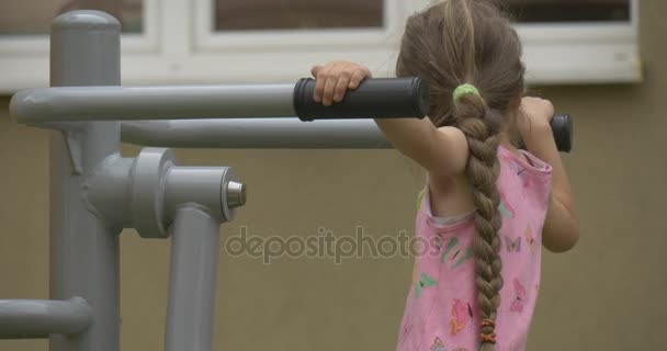 Girl Tries to Carry Out Sports Exercises on Bars — Stock Video