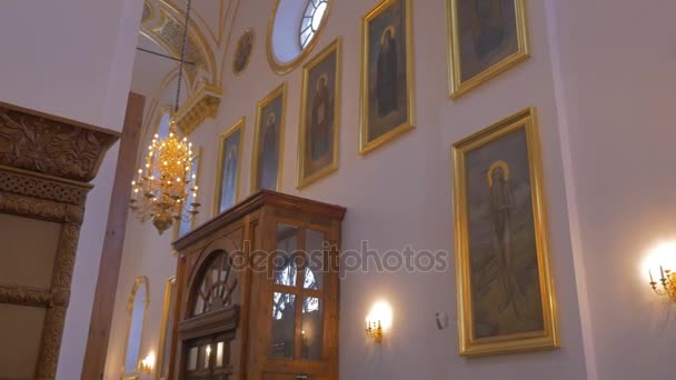 Iconos de aspecto dorado, candelabros, ventanas redondas dentro de la catedral ortodoxa cristiana en Liev, Ucrania — Vídeo de stock