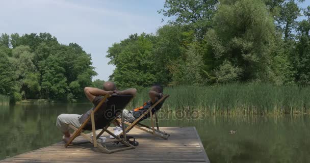 Two Men Sit on a Small Folding Chairs — Stock Video