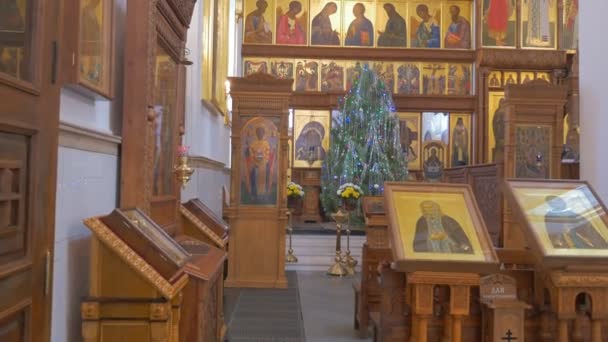 Eine großartig aussehende Ikonostase mit vielen Heiligen und prachtvollen Ikonen davor in einer orthodoxen Kathedrale in Kiew, Ukraine — Stockvideo