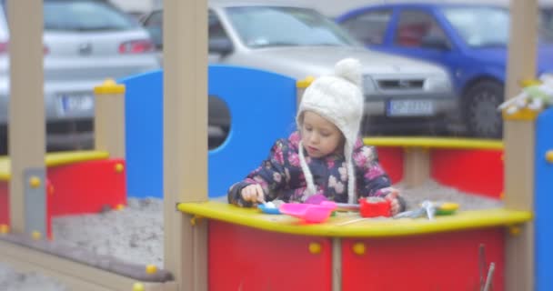 Menina brincando na caixa de areia fazendo bolos — Vídeo de Stock