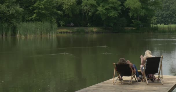 Дві дорослі жінки відпочивати на розкладні крісла — стокове відео