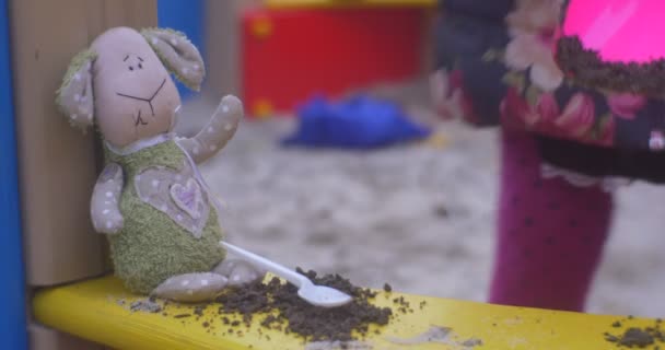 Mjuk leksak lamm i en sandlåda. — Stockvideo