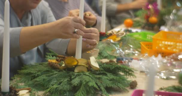 Frauen sitzen in einer Reihe und sammeln die Weihnachtskomposition. — Stockvideo