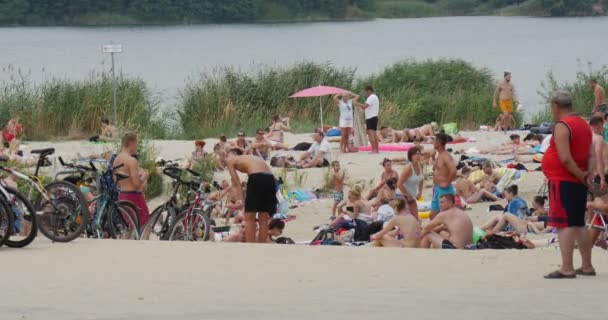 Sok turista, amelyek a többi, a tó partján, csodálatos homokos, és lenyűgöző Waterscape, Lengyelország Időjárás — Stock videók