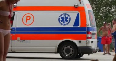 bir ambulans araba bir Steadicam kamera ile çekim bir dinlenme, Opole, Polonya, Lake Bolko sahip yarı çıplak turist arasında hareket eder