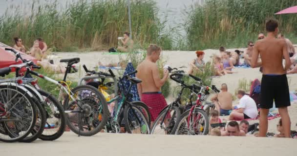 Différentes personnes se reposent sur la rive du lac Bolko avec Sandy Plage et Nice Greenary autour en été — Video