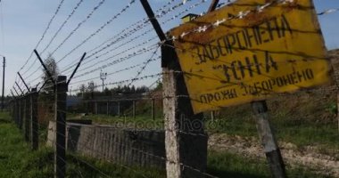 Korkunç görünümlü Kablolu çit ve bir muhafız Kulesi sarı yasağı işaretiyle, Ukrayna'da bir petrol depolama çevreleyen dikenli