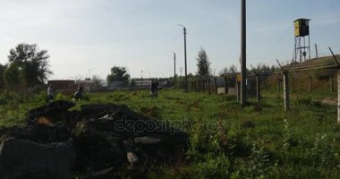 bir yığın beton çöp ve bir kasvetli Bob tel, bazı petrol depolama ve toprak örneği arka planda yaz aylarında iki insan korunması