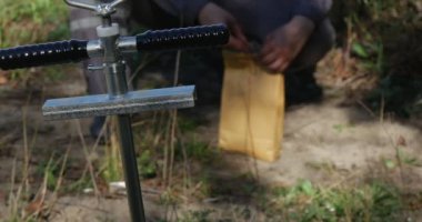 Metal el Delme Brace için arazi ve arkasında adam çalışıyor kağıt paketi ile örnekleri, toprak alınan yakınındaki bazı petrol depolama yaz kadar kravat için
